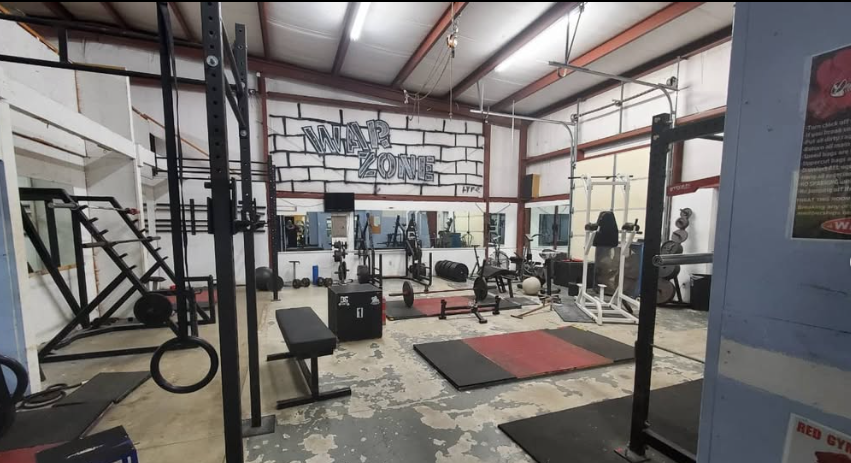 War Zone training floor at Dover Gym with power racks, benches, and lifting platforms